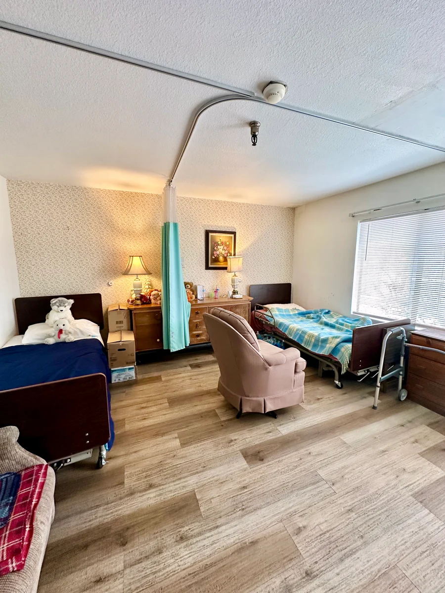 Shared room with two beds, an armchair and a window at the home